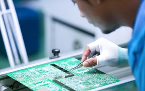 Man working on a circuitboard in a technology factory