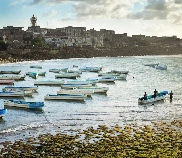 Men in a rowing boat in a costal town