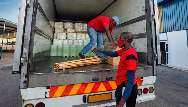 Two men loading products off the back of a lorry