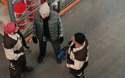 A group of three warehouse workers talking