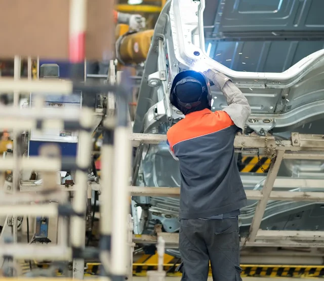 Man welding a car in a factory