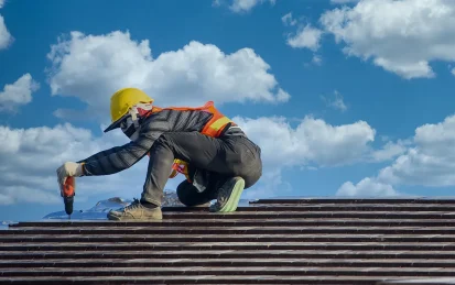 Worker in high-vis jacket and hard hat repairing a roof