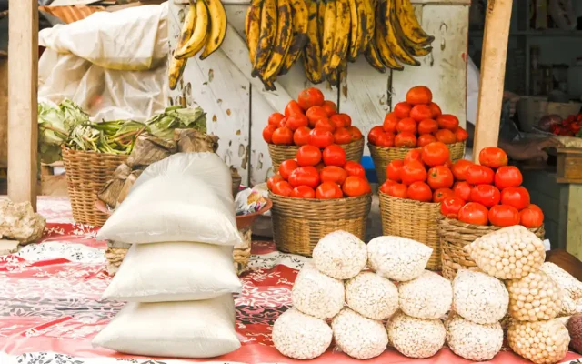 A market stall selling fresh fruit and sacks of nuts