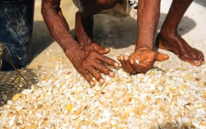 A worker sifting through a pile of gemstones