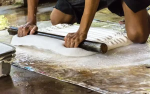 A worker rolling out rubber