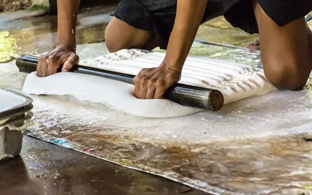 A worker rolling out rubber