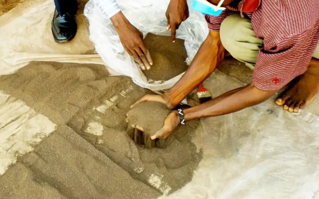Workers looking through mined material