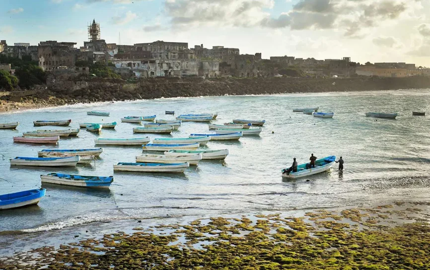Men in a rowing boat in a costal town