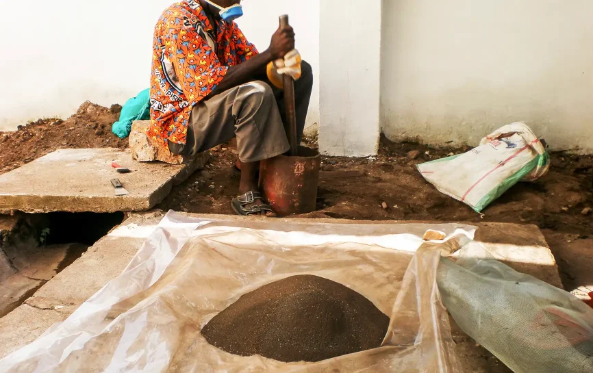 A worker sifting coltan