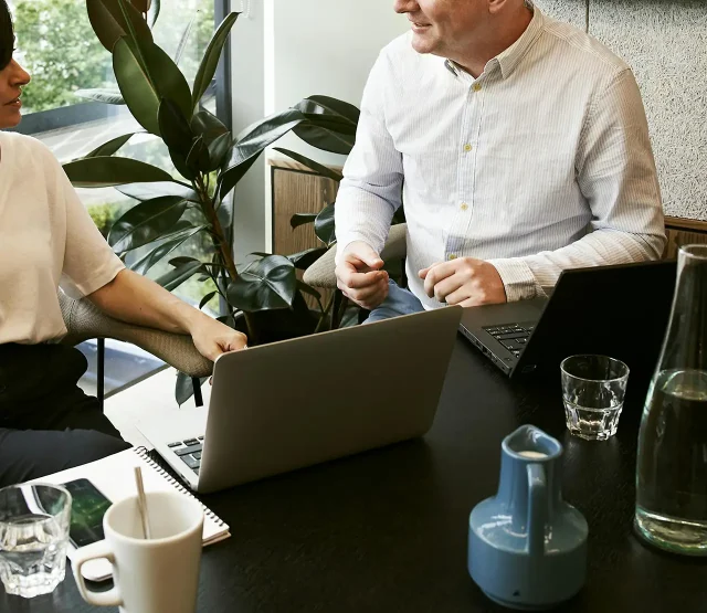 Two people in an office with laptops