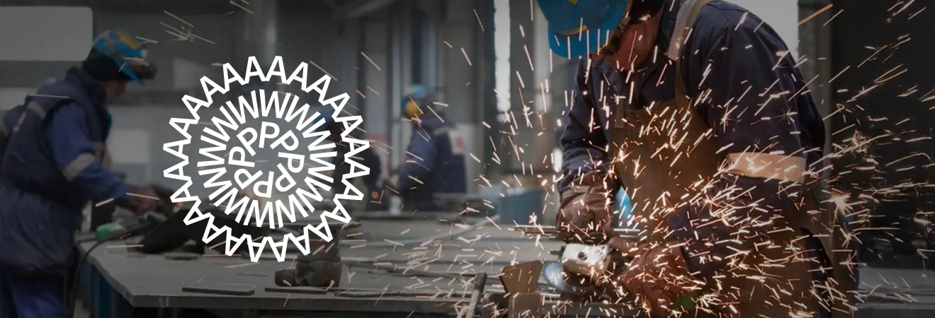 Workers in a metal workshop using power tools