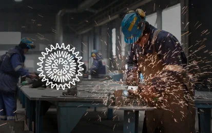 Workers in a metal workshop using power tools