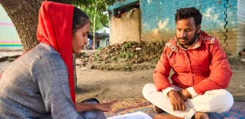 Two people sat on the floor looking at resources