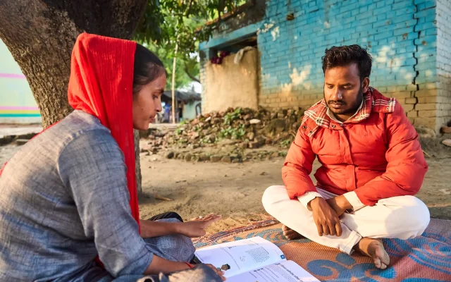 Two people sat on the floor looking at resources