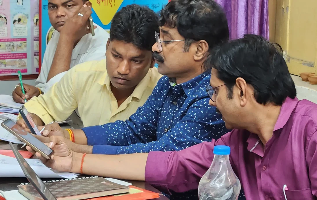 Practicing digital data collection in India: Three men looking at mobile phones