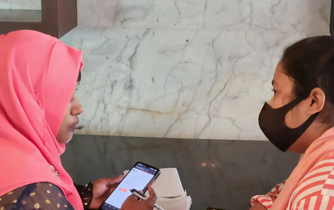 Practicing digital data collection in Bangladesh: Two women looking at a mobile phone