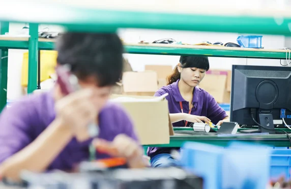 Two workers in an Asian tech factory